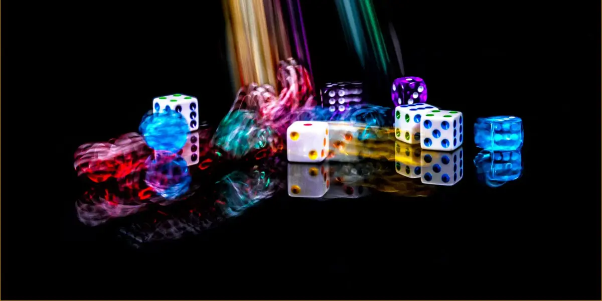 Colourful dice tumbling in streaks of light on a dark background